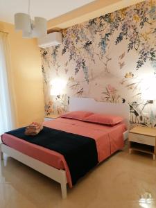 1 dormitorio con 1 cama con pared de flores en Raggio di Sole, en Gaeta