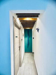 un pasillo con una puerta y una pared azul en La Siesta en La Maddalena