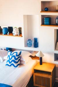 a bedroom with a bed with blue dishes on shelves at Hôtel La Mandarine in Saint-Tropez