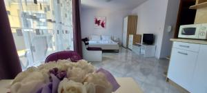 ein Wohnzimmer mit einem Tisch und einer Blumenvase in der Unterkunft Olympia Beach Complex in Rawda