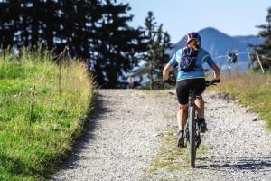 une personne empruntant un vélo sur un chemin de terre dans l'établissement Belambra Clubs Les Saisies - Les Embrunes - Ski pass included, à Villard-sur-Doron