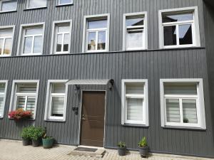 a gray building with a door and windows at Courtyard Condo Sunset in Liepāja