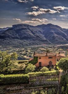 une maison sur une colline avec des montagnes en arrière-plan dans l'établissement Wonderful Serena, à Coreglia Antelminelli