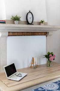 a laptop sitting on a fireplace mantle with a clock at Holiday home Horizont in Supetar +23 photos