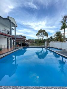 una piscina azul frente a una casa en MY VILLA PD, en Port Dickson