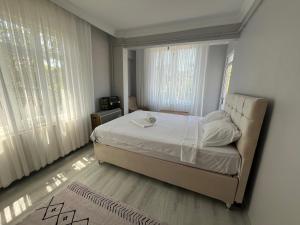 a bedroom with a bed in a room with windows at Airport See Viem Apartment in Arnavutköy