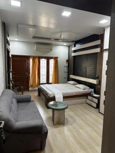 una camera con letto, divano e tavolo di Temple View Home Stay a Tiruvannāmalai