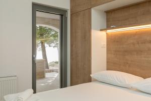 ein Schlafzimmer mit einem weißen Bett mit einem hölzernen Kopfteil in der Unterkunft Villa Brela apartments in Brela + 70 Fotos