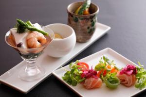 dwa talerze jedzenia z krewetkami i warzywami na nich w obiekcie Arima Hot Spring Ryokan Hanamusubi w mieście Kobe