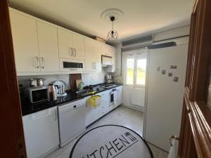 a kitchen with white cabinets and white appliances at Airport See Viem See Apartment in Arnavutköy