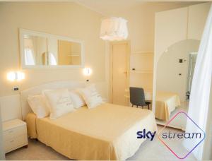 1 dormitorio con 1 cama con espejo y silla en Sirena Boutique Hotel, en Gabicce Mare