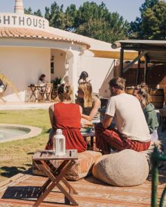 a group of people sitting at an outdoor table at The Lighthouse Hostel in Sagres