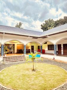 a house with a palm tree in front of it at Tahan Hostel in Puerto Princesa City