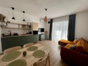 a living room with a dining table and a kitchen at Best Apartman Boglár in Balatonboglár