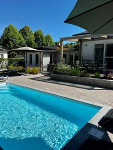 een blauw zwembad voor een huis bij Best Apartman Boglár in Balatonboglár