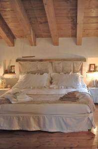 a bedroom with a large bed with white sheets and pillows at B&B Il Posto delle Rose in Almenno San Salvatore