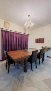 a dining room with a wooden table and chairs at MY VILLA PD in Port Dickson