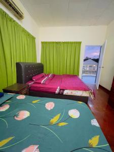 1 dormitorio con 1 cama con cortinas verdes y alfombra verde en MY VILLA PD, en Port Dickson