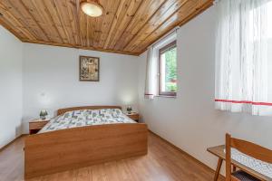 una camera con letto e soffitto in legno di Vineyard Homestead Vrtin - Happy Rentals a Dragatuš