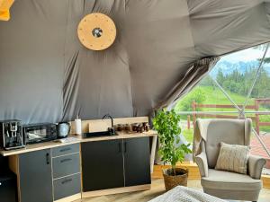 a kitchen in a tent with a chair and a table at Tatra Glamp Tarasówka in Poronin
