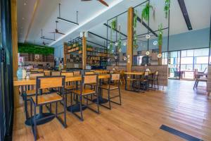 un restaurant avec des tables et des chaises en bois dans une salle dans l'établissement Rawayana West Villas & Kids Park, à Rawai Beach