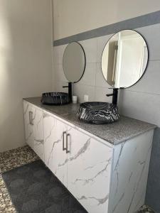 a bathroom with a vanity with a mirror on it at Casa Blue Print Mahebourg in Mahébourg