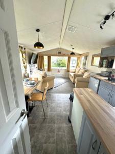 a kitchen and living room with a table in a caravan at Revamped & Upgraded 6 Berth Static Caravan on Southview Skegness in Skegness