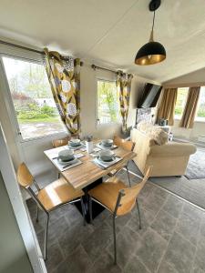 un soggiorno con tavolo, sedie e divano di Revamped & Upgraded 6 Berth Static Caravan on Southview Skegness a Skegness
