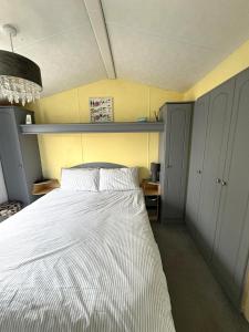 una camera da letto con un grande letto con lenzuola bianche di Revamped & Upgraded 6 Berth Static Caravan on Southview Skegness a Skegness