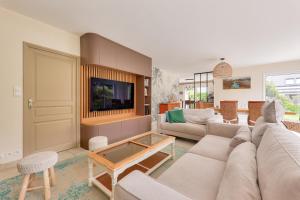 a living room with a couch and a tv at Maison de pierre pour 8 avec beau jardin in Saint-Gildas-de-Rhuys