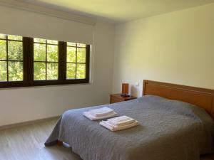 een slaapkamer met een bed met twee handdoeken erop bij Leiras da Cachada - Gerês in Valdosende