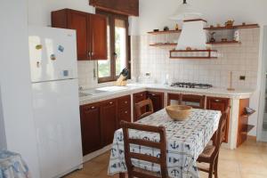 a kitchen with a table and a white refrigerator at Casa Centro in Favignana