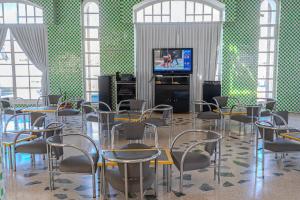 Habitación con mesas, sillas y TV. en Appart-Hôtel Tagadirt en Agadir