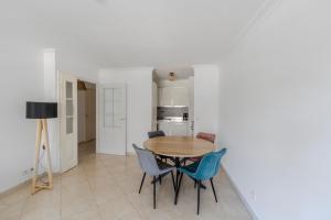 a dining room with a wooden table and blue chairs at Appartement Marina Privée centre-ville Mandelieu in Mandelieu-la-Napoule