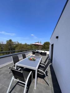 a white table and chairs on a balcony at Penthouse M1 in Neunkirchen