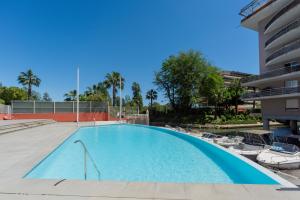 a large swimming pool with chairs and a building at Appartement Marina Privée centre-ville Mandelieu in Mandelieu-la-Napoule +5 photos