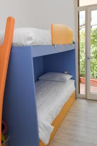 two bunk beds in a room with a window at Favola Bella The panoramic penthouse in Bardolino