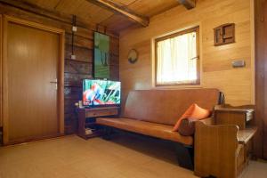 uma sala de estar com um sofá e uma televisão em Kuća za odmor Slunjčica em Slunj