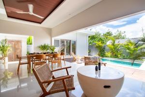 an open living room with a table and chairs and a pool at CANGGU - 3BDR Villa with Private Pool and Rooftop and Ricefield View in Kerobokan