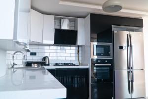 a kitchen with a stainless steel refrigerator and white cabinets at Royal Blue Luxury Villas-İstanbul-Şile in Istanbul