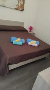 a bed with blue and yellow pillows on it at Elegance apartment Taormina in Letojanni