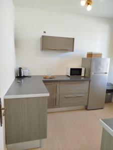 una cucina con bancone e frigorifero di Gîte "Le Para" en plein centre de Ste Mère Église a Sainte-Mère-Église