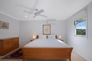 une chambre avec un lit et un ventilateur de plafond dans l'établissement Paddington Cottage - A Classic Queenslander Stay, à Brisbane