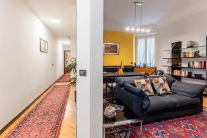Homeby - Appartamento Simonetta - Porta Romana في ميلانو: غرفة معيشة مع أريكة وطاولة