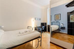 Homeby - Appartamento Simonetta - Porta Romana في ميلانو: غرفة نوم فيها سرير ومكتب