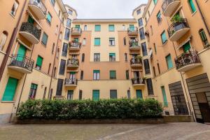 Homeby - Appartamento Simonetta - Porta Romana في ميلانو: عمارة سكنية امامها تحوط