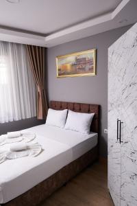 a bedroom with a large bed with white sheets at Pequena Casa Apart in Istanbul