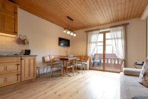 cocina y sala de estar con mesa y comedor en Leindlhof en Kössen