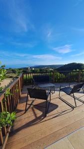 a deck with two chairs and a bench on it at Villa DEA in Aglientu +8 photos