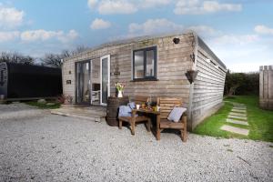 a tiny house with a table and two chairs at Wheal Jewel - Hot Tub - On-site Activities - Free WiFi - Parking in Helston